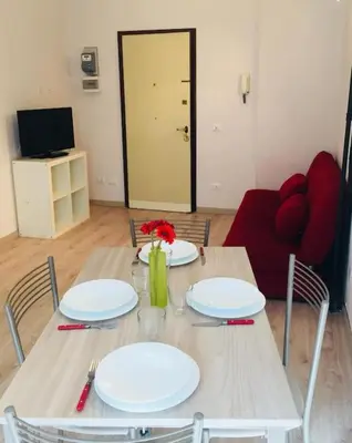 a table with plates and a vase with flowers on it at Maison de' Trastevere in Rome