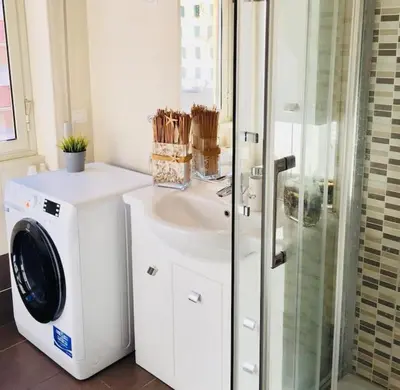 a bathroom with a washing machine and a sink at Maison de' Trastevere in Rome