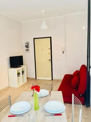 a living room with a table and a red couch at Maison de' Trastevere in Rome