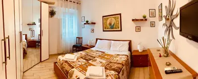 a bedroom with a bed and a table and a television at Family in Rome in Rome
