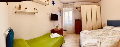 a small bedroom with a bed and a green bench at Family in Rome in Rome