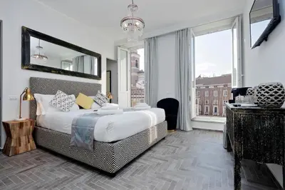 a bedroom with a large bed and a large window at Boutique Suites della Croce in Rome