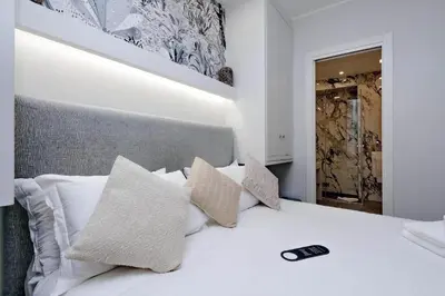 a bedroom with a white bed with pillows at Boutique Suites della Croce in Rome