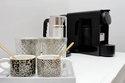 two cups on a counter next to a coffee maker at Boutique Suites della Croce in Rome