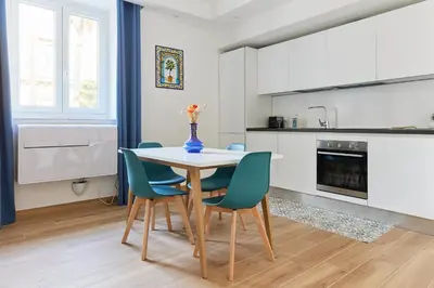 a kitchen with a table and blue chairs at iFlat Lovely Modern Apartment in Rome