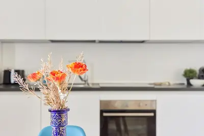 a blue vase with orange flowers sitting on a table at iFlat Lovely Modern Apartment in Rome