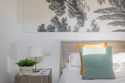 a bed with a pillow and a table with a lamp at iFlat Historic flat in campo de fiori in Rome