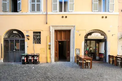 a yellow building with two doors and a street at iFlat Historic flat in campo de fiori in Rome