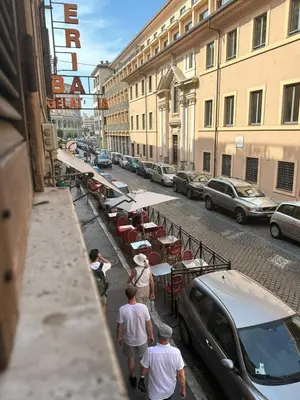 a group of people walking down a street with tables and cars at 150 meters from the Colosseum - Appartmento Gladiatore in Rome