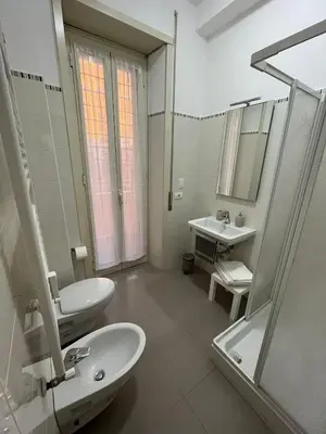 a white bathroom with two sinks and a shower at Monti Deluxe Apartment in Rome