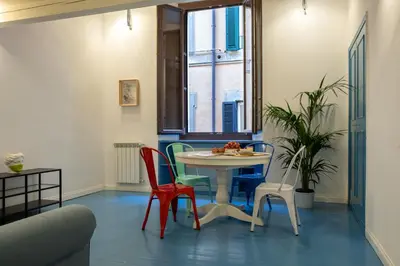 a table and chairs in a room with a window at Farina 36 in Rome