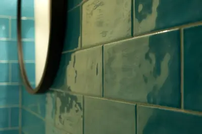 a blue tiled wall with a mirror in a bathroom at Farina 36 in Rome