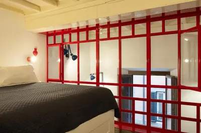 a bedroom with red framed windows and a bed at Farina 36 in Rome