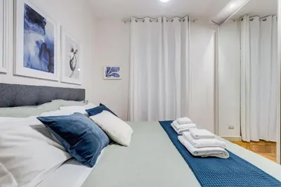a bedroom with a bed with blue and white pillows at BDC - The Platinum 2-Bdr apt @Spanish Steps in Rome