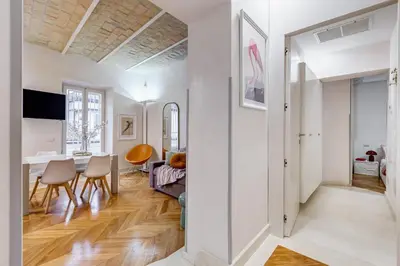 a living room and dining room with white walls and wood floors at BDC - The Platinum 2-Bdr apt @Spanish Steps in Rome