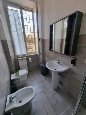 a bathroom with two sinks and a mirror at Loftiense Roma in Rome
