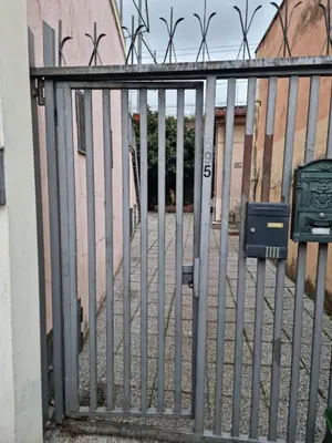 a metal fence with a gate in front of a building at Loftiense Roma in Rome