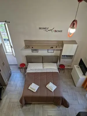 a bedroom with a bed and a sign that reads home sweet home at Loftiense Roma in Rome