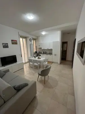 a living room with a couch and a table and a kitchen at Monti Royal Apartment in Rome