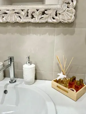 a bathroom sink with a mirror and a tray of soap at Colosseo House in Rome
