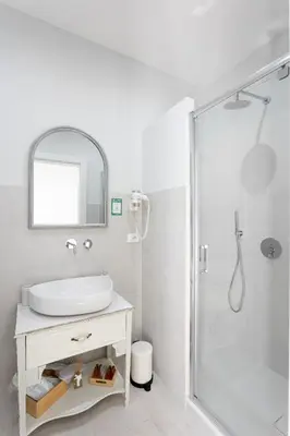 a white bathroom with a sink and a shower at Colosseo House in Rome