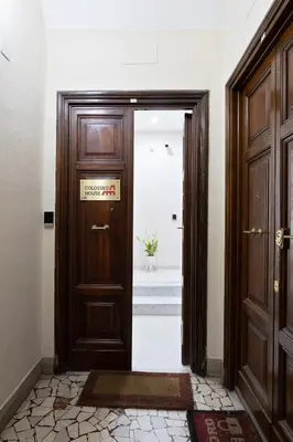 a wooden door with a sign on it in a hallway at Colosseo House in Rome
