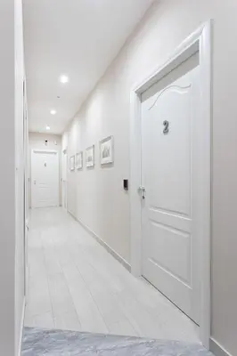 an empty hallway with white walls and a white door at Colosseo House in Rome