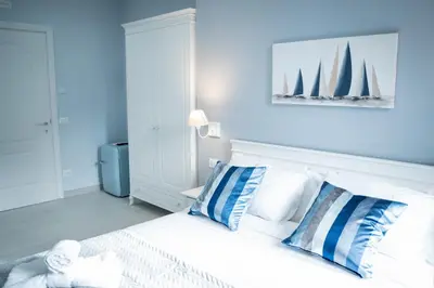 a bedroom with a white bed with blue and white pillows at Colosseo House in Rome
