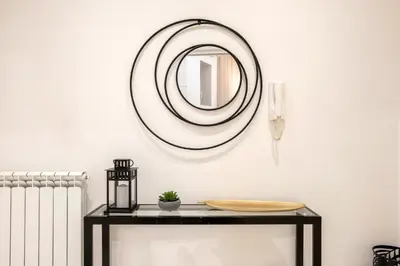 a mirror on a wall above a table with a radiator at Angelique Boutique in Rome