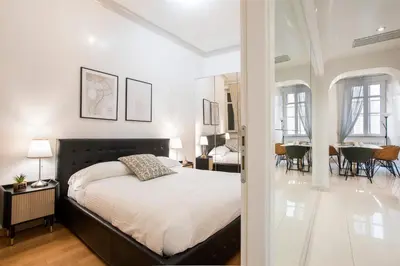 a bedroom with a large bed and a dining room at Angelique Boutique in Rome