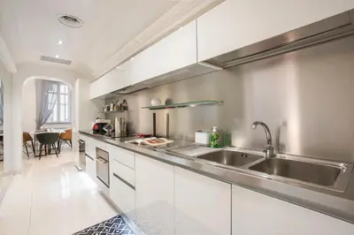 a kitchen with white cabinets and a stainless steel sink at Angelique Boutique in Rome