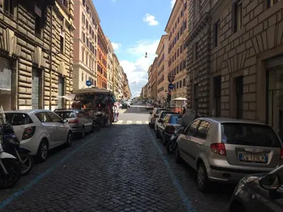 a street with cars parked on the side of the road at Casa Vacanza Colosseo in Rome