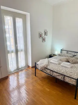 a bedroom with a bed and a wooden floor at Volupta's House Janiculum Hill in Rome