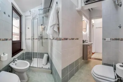 a bathroom with a toilet and a shower and a sink at ATRHOME - Canova Essential in Rome