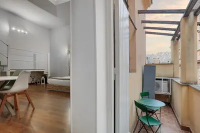 a room with a table and chairs and a bedroom at ATRHOME - Canova Essential in Rome
