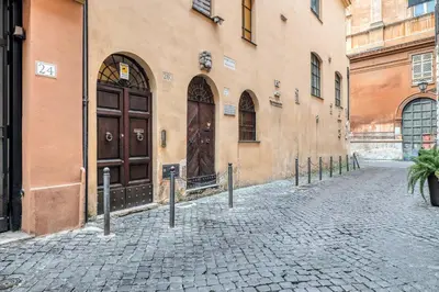 a building with a brown door on a cobblestone street at ATRHOME - Canova Essential in Rome