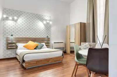 a bedroom with a bed and a table and a chair at ATRHOME - Canova Essential in Rome