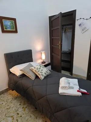 a bedroom with a bed and a lamp and a door at GuestHouse Aurora ML in Rome