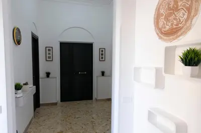a hallway with white walls and a black door at GuestHouse Aurora ML in Rome