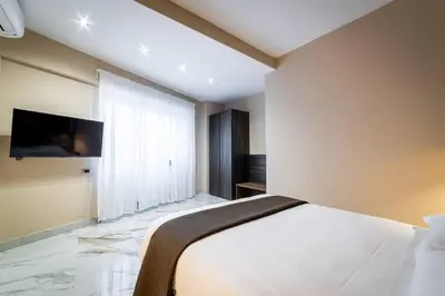 a bedroom with a white bed and a tv on the wall at 50 Gandino Deluxe in Rome