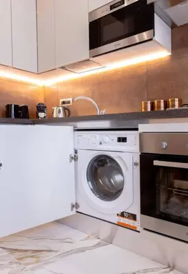 a kitchen with a washing machine and a microwave at 42 Gandino Superior in Rome