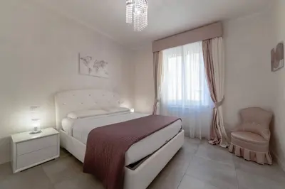 a bedroom with a bed and a chair and a window at 35 Gozzadini in Rome