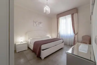 a white bedroom with a bed and a window at 35 Gozzadini in Rome
