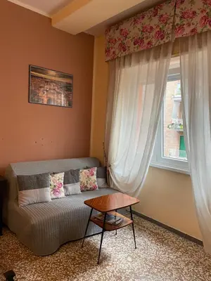 a living room with a couch and a window at Ila Guest House in Rome