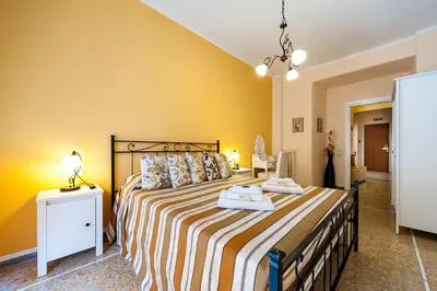 a bedroom with a large bed with yellow walls at Ila Guest House in Rome