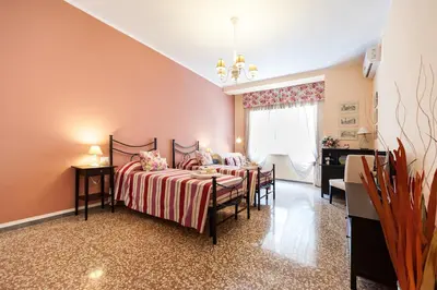a bedroom with two beds and a table and a window at Ila Guest House in Rome