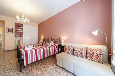 a bedroom with two beds and a couch at Ila Guest House in Rome