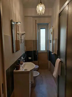 a bathroom with a sink and a toilet and a chandelier at Tre Fiori in Rome