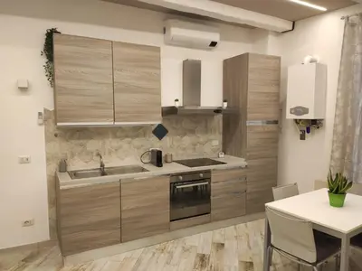 a kitchen with wooden cabinets and a sink and a table at AlVin Casa in Rome
