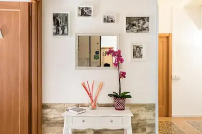 a white table with a vase of flowers on it at Vatican Secret Rooms in Rome